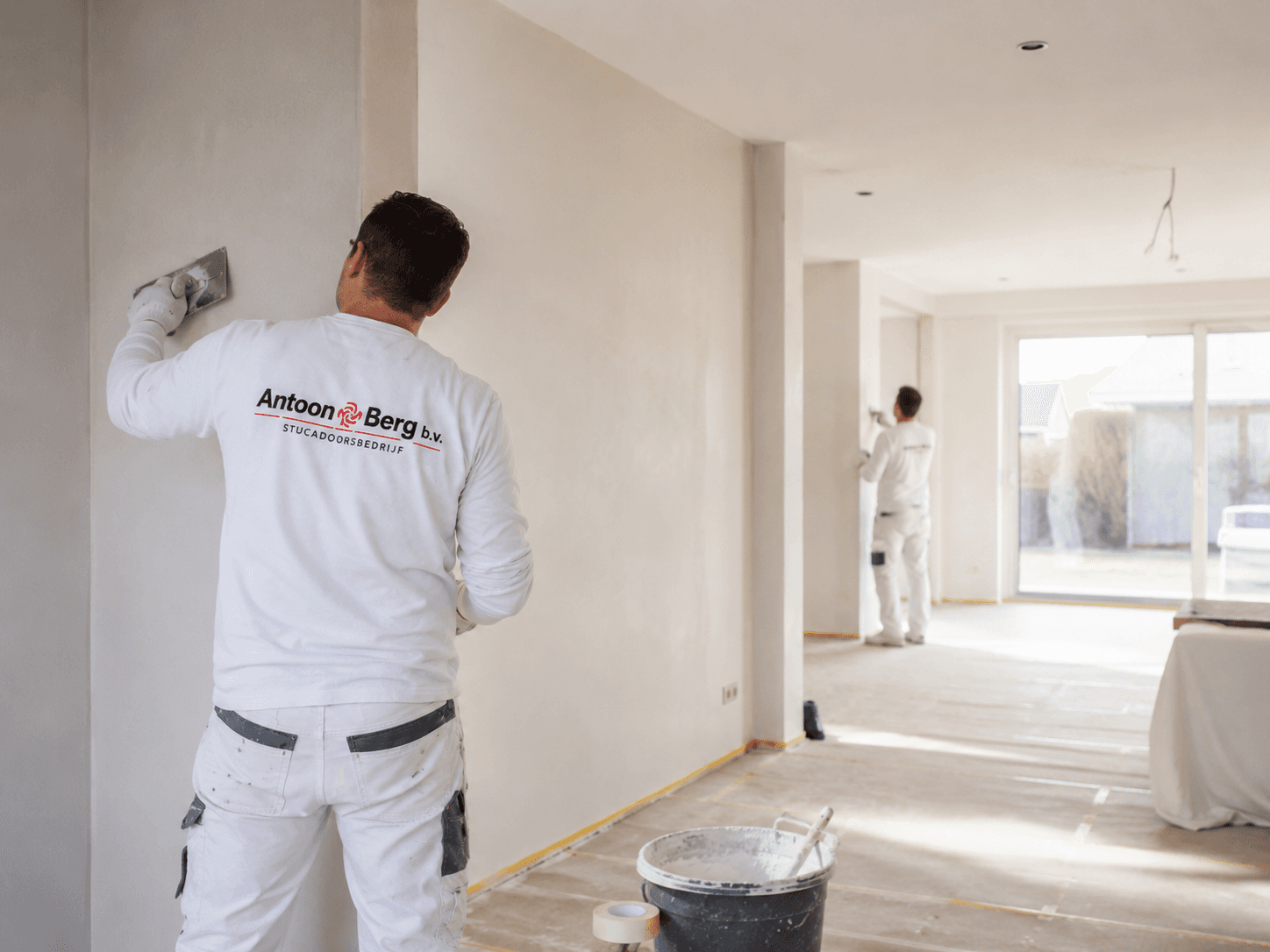 Vakman bezig met nette wandafwerking voor een woning in Brabant