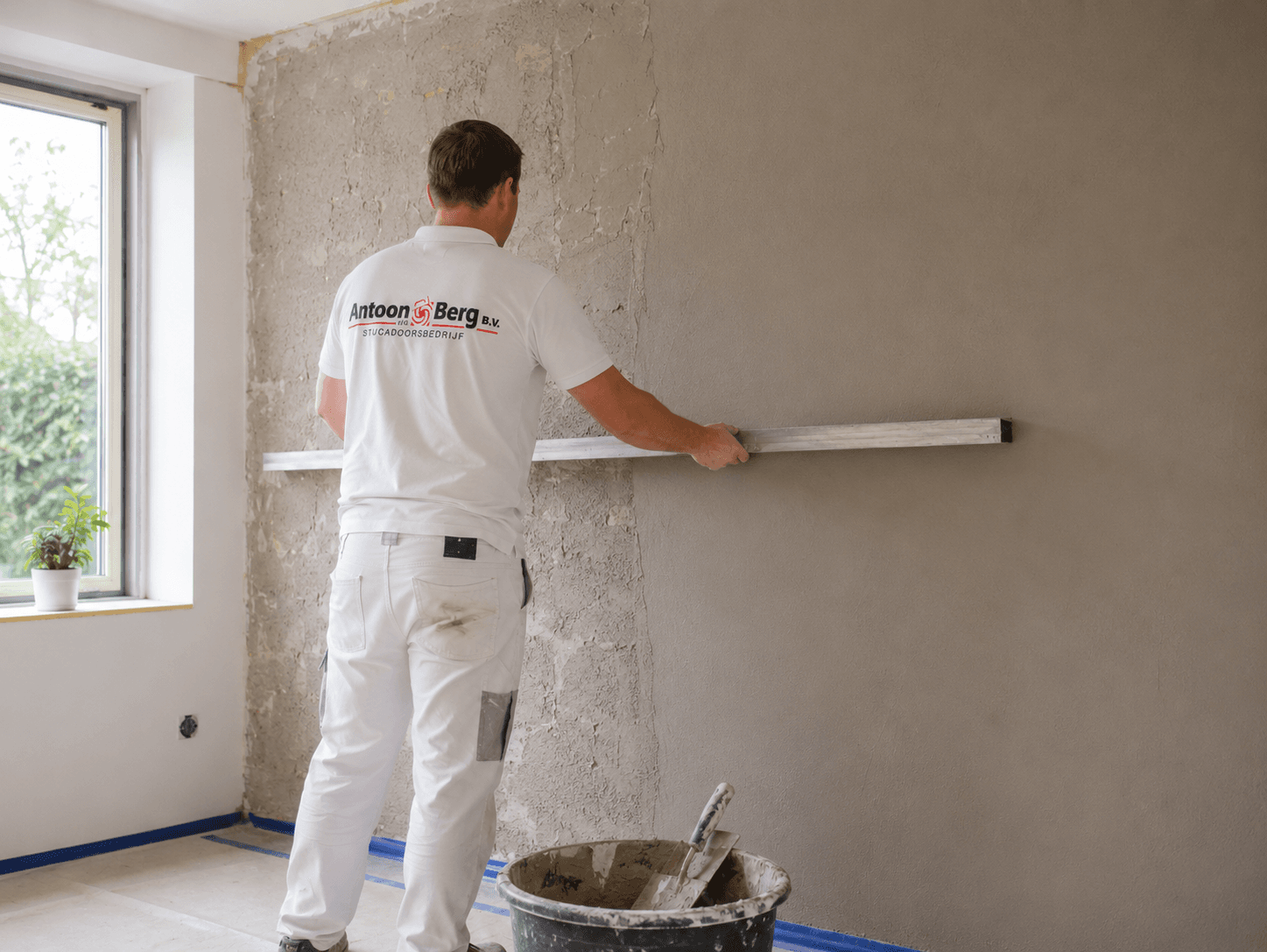 Vakman vlakt een ruwe wand uit met raapwerk